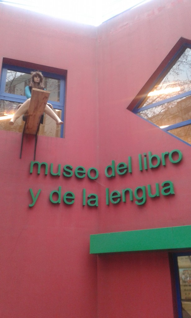 Talita sentada sobre el tablón en la ventana del museo